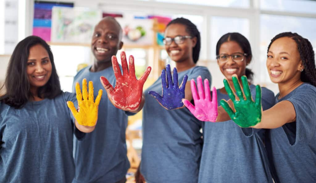 Teaching staff at a childcare center with paint on their hands.